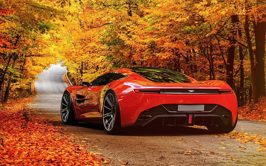Red Aston Martin Supercar Parked on a Winding Road Surrounded by Vibrant Autumn Foliage HD wallpaper