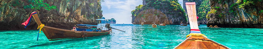 Traditional Thai Longtail Boats in Turquoise Waters with Limestone Cliffs HD wallpaper