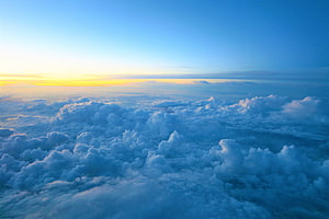 Aerial View of a Vast Sea of Clouds at Golden Hour with a Clear Blue Sky HD wallpaper