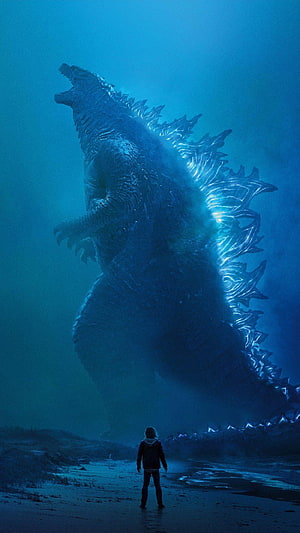 Godzilla Towering Over a Lone Figure on a Misty Shore with Glowing Dorsal Fins HD phone wallpaper