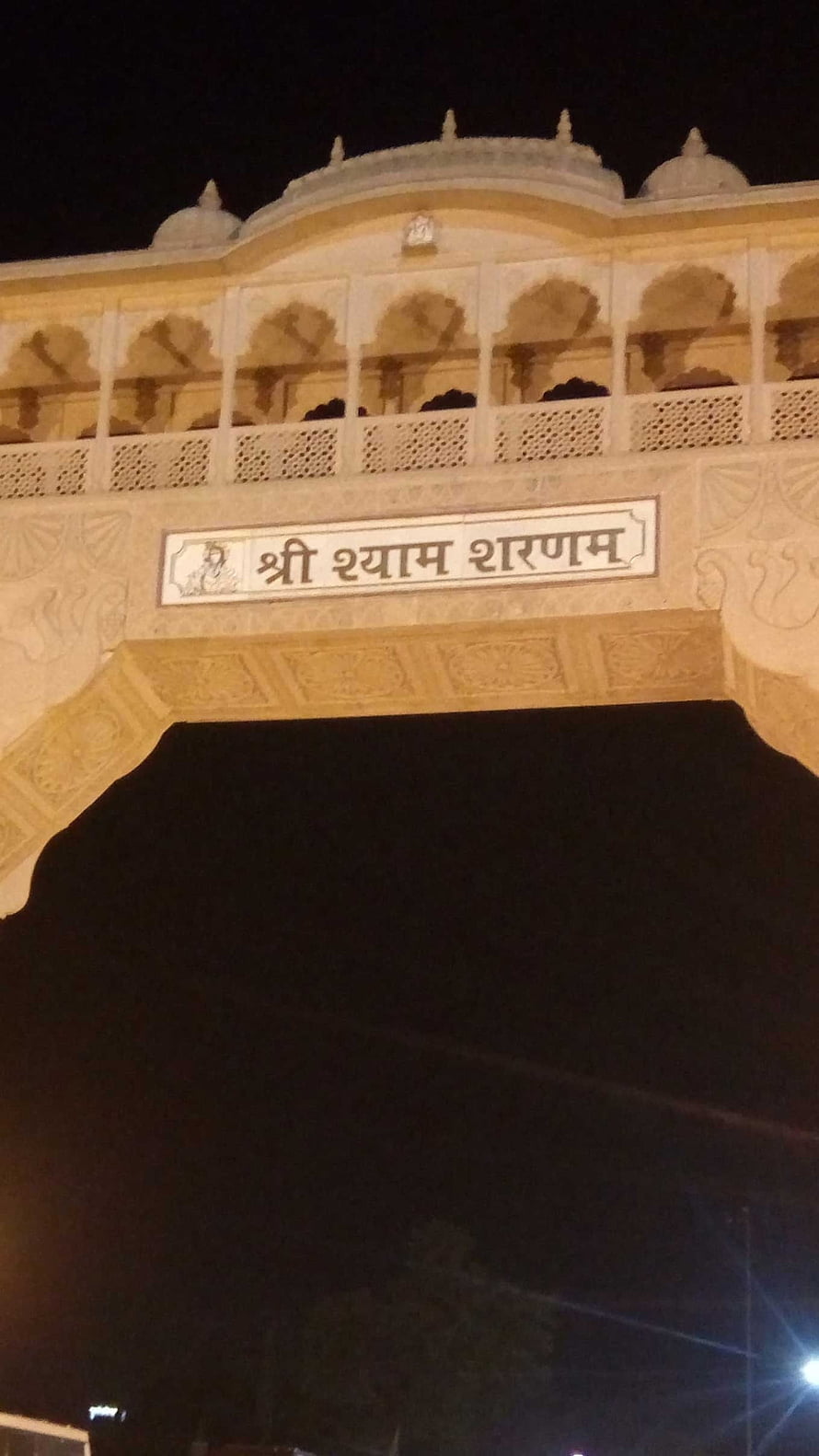 Khatu Shyam Temple Gateway Illuminated at Night with Intricate Carved Stone Archway and Domes HD phone wallpaper