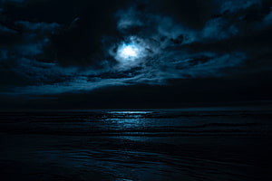 Moody Night Ocean Scene with Moonlight Breaking Through Dark Storm Clouds HD wallpaper