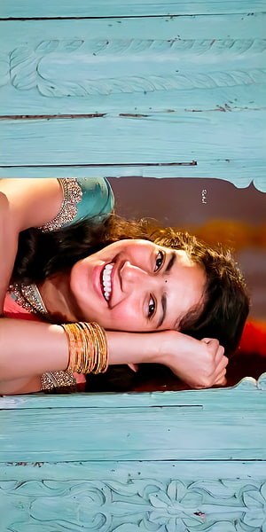 Sai Pallavi smiling portrait with traditional bangles and teal carved wooden frame HD phone wallpaper