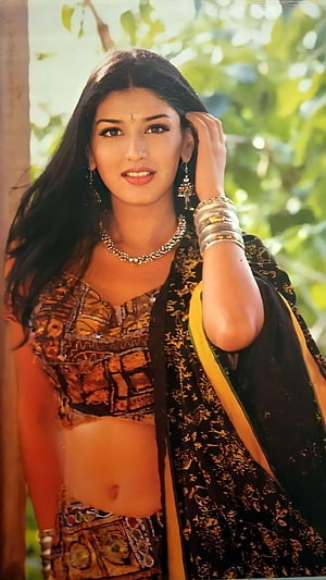 Sonali Bendre in Traditional Indian Attire with Gold Jewelry and Floral Background HD phone wallpaper