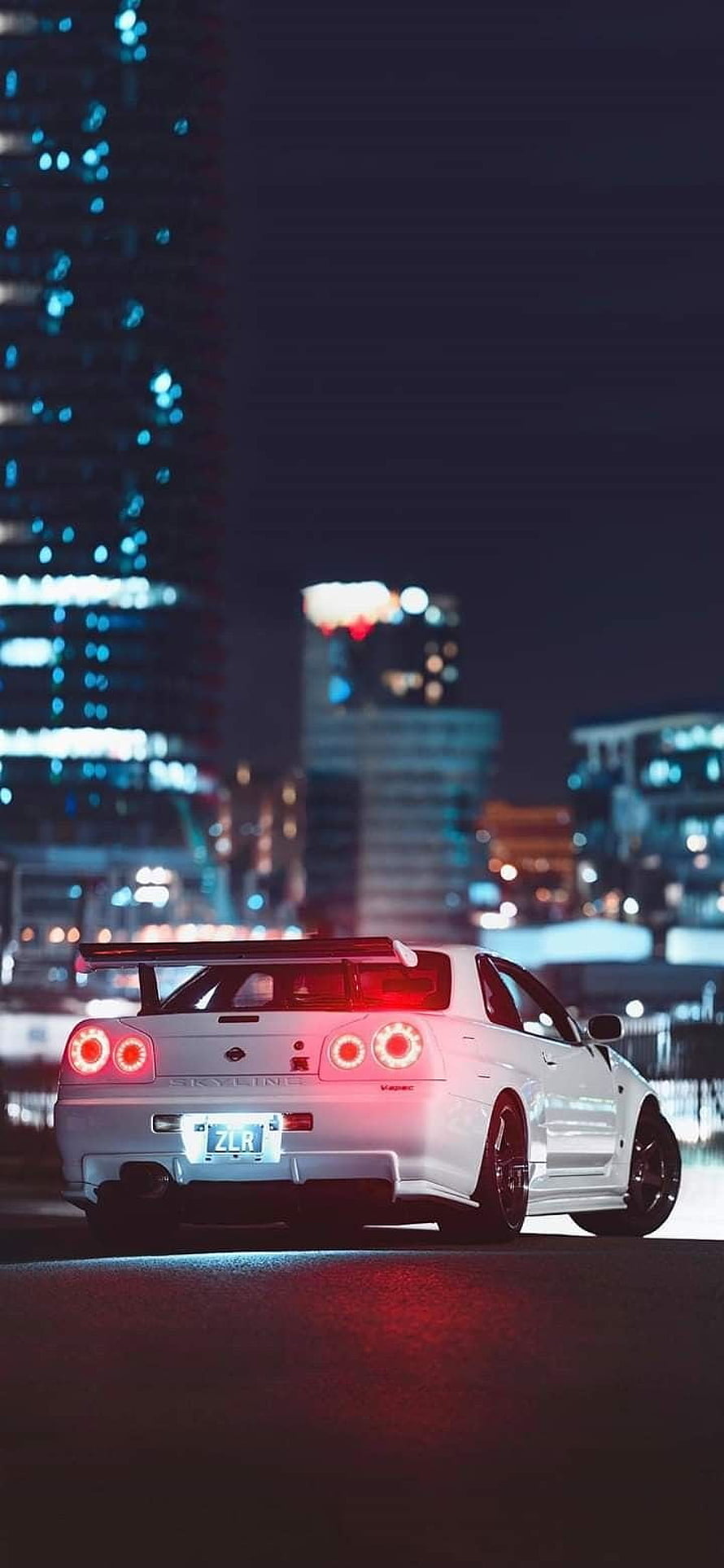 White Nissan Skyline R34 GT-R Rear View on a Night City Street with Glowing Taillights HD phone wallpaper