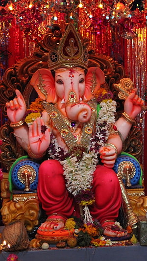 Ornate Ganesha Murti Adorned With Flower Garlands And Gold Jewelry In Temple Setting HD phone wallpaper