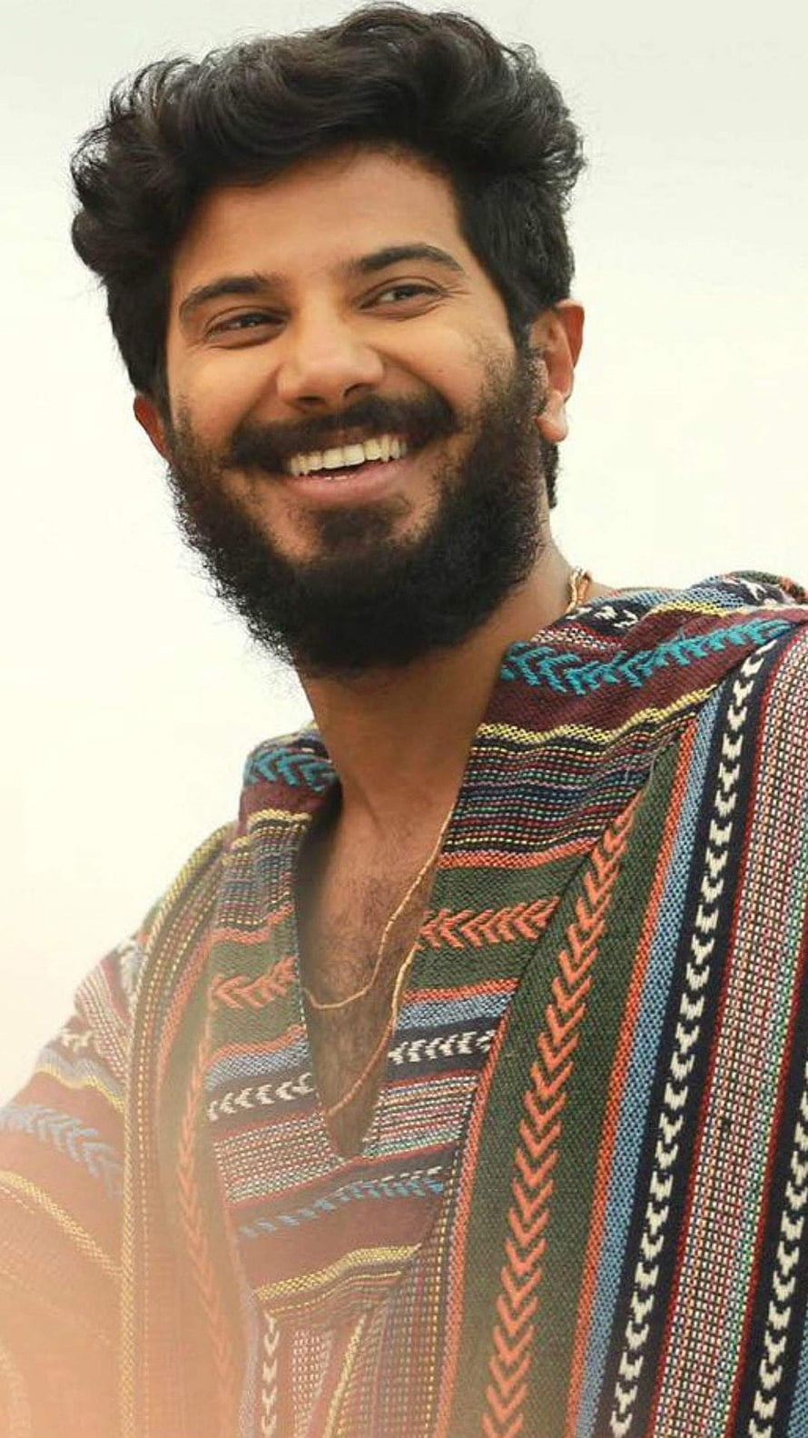 Dulquer Salmaan smiling portrait in colorful patterned shawl HD phone wallpaper
