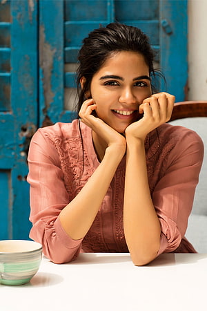 Kalyani Priyadarshan smiling portrait in pink blouse against a weathered blue wooden door HD phone wallpaper