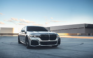 Silver BMW 7 Series Luxury Sedan Parked on Concrete Rooftop at Sunset HD wallpaper