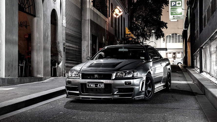 Silver Nissan Skyline GT-R R34 Parked on Urban Street at Night HD wallpaper