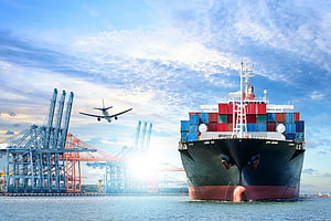 Massive Container Ship Docked at Port with Cargo Cranes and Airplane in Sky HD wallpaper