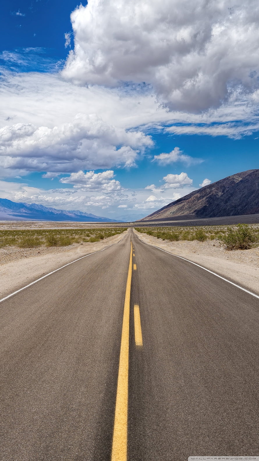 Endless Desert Highway Stretching Toward Distant Mountains Under a Bright Blue Sky HD phone wallpaper