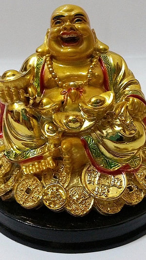 Golden Laughing Buddha Statue Surrounded by Coins and Ingot Symbols of Wealth HD phone wallpaper
