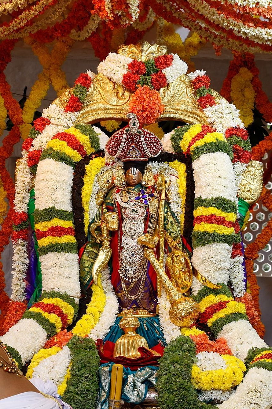 Sri Malayappa Swamy deity adorned with vibrant flower garlands at Tirumala temple HD phone wallpaper