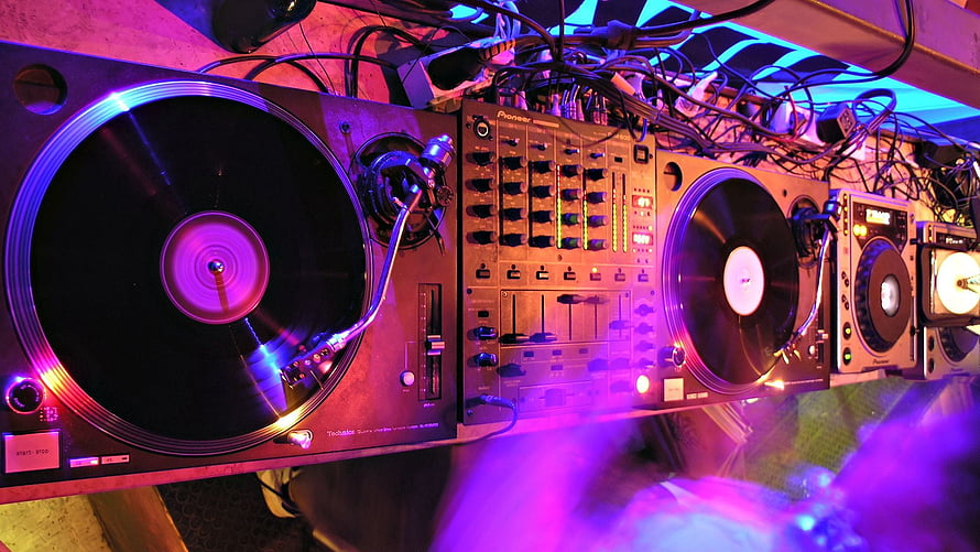 Professional DJ Setup With Turntables And Mixer Under Neon Club Lighting HD wallpaper