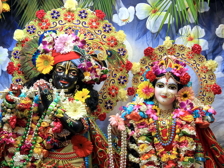 Radha Krishna Deities Adorned in Vibrant Floral Garlands and Ornate Jewelry HD wallpaper