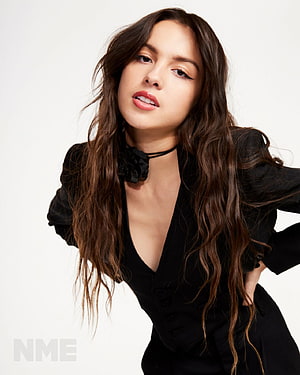 Olivia Rodrigo in Black Blazer with Floral Choker and Long Wavy Hair HD phone wallpaper