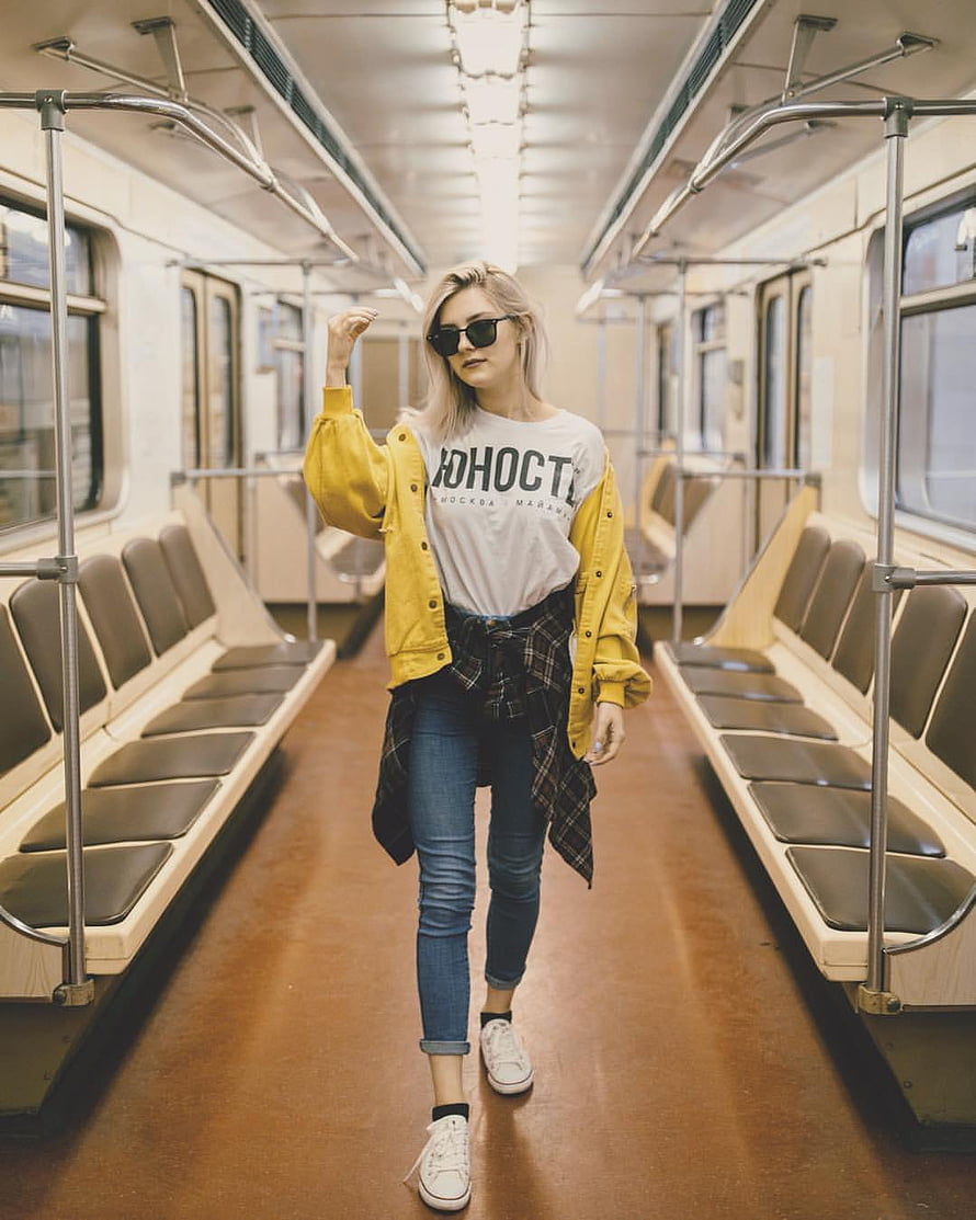 Eva Elfie in a yellow jacket and sunglasses walking through a vintage subway car HD phone wallpaper
