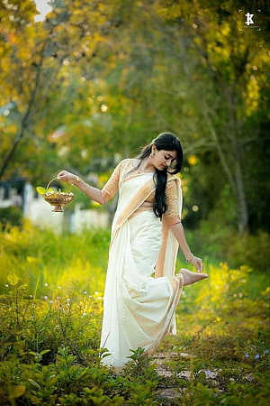 Elegant Woman in White Saree Holding Traditional Basket in Lush Green Garden HD phone wallpaper