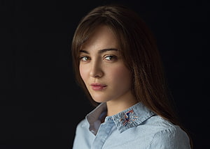 Studio Portrait of a Young Woman in a Light Blue Embroidered Shirt Against a Dark Background HD wallpaper