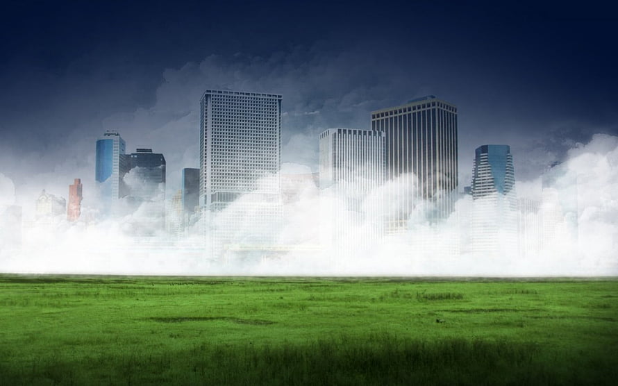 City skyline emerging from low fog over a vibrant green meadow under a dark stormy sky HD wallpaper