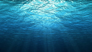 Sunlight Filtering Through Deep Blue Ocean Water Surface HD wallpaper