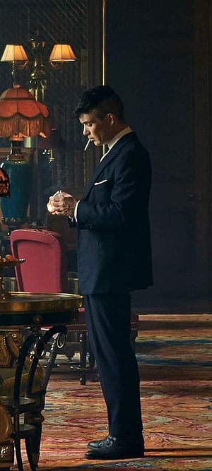 Thomas Shelby from Peaky Blinders in a dark suit smoking a cigarette in an ornate vintage room HD phone wallpaper