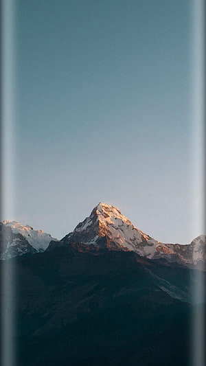 Majestic Snow-Capped Mountain Peak at Golden Hour with Clear Blue Sky HD phone wallpaper