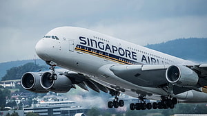 Singapore Airlines Airbus A380 taking off with landing gear deployed over a city HD wallpaper