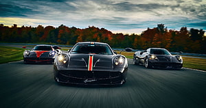 Three Pagani Huayra Supercars Racing on a Scenic Autumn Track at Dusk HD wallpaper