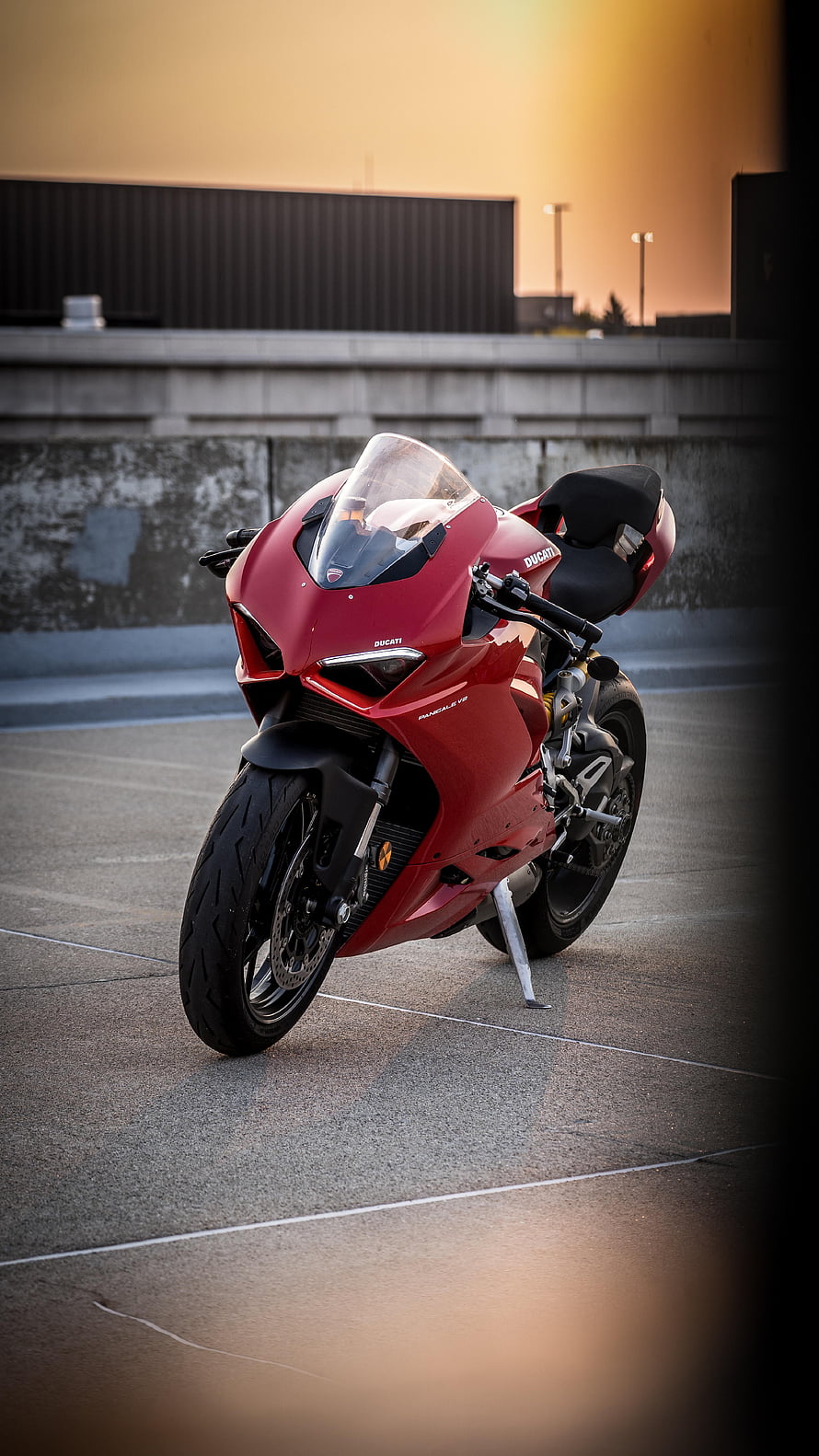 Red Ducati Panigale V2 Superbike Parked on Concrete at Golden Hour HD phone wallpaper