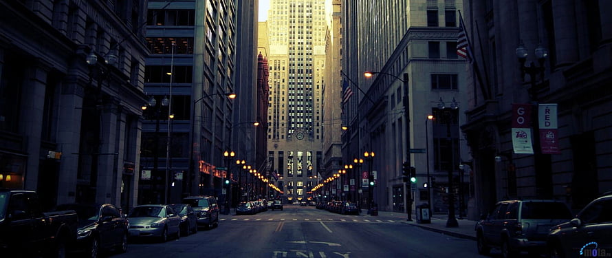 Chicago Street Canyon at Dusk with Tall Skyscrapers and Parked Cars HD wallpaper