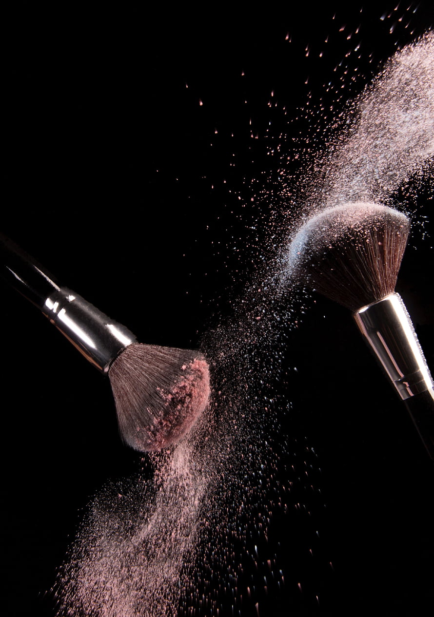 Dramatic Makeup Brushes and Powder Dust Explosion on Black Background HD phone wallpaper