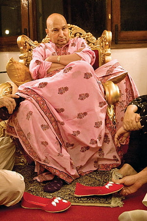 Bald man in pink traditional attire seated on ornate golden throne with red embroidered shoes, Jai Guru ji, Guruji HD phone wallpaper