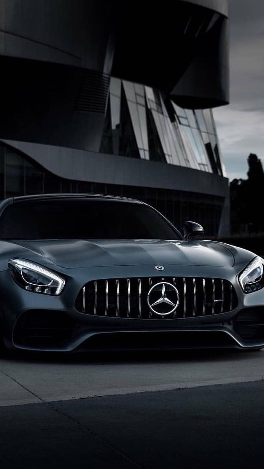 Matte Black Mercedes-AMG GT Front View Parked Before Modern Glass Architecture HD phone wallpaper