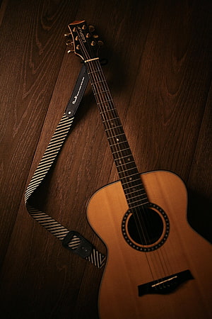 Acoustic Guitar with Striped Strap on Dark Wood Floor HD phone wallpaper