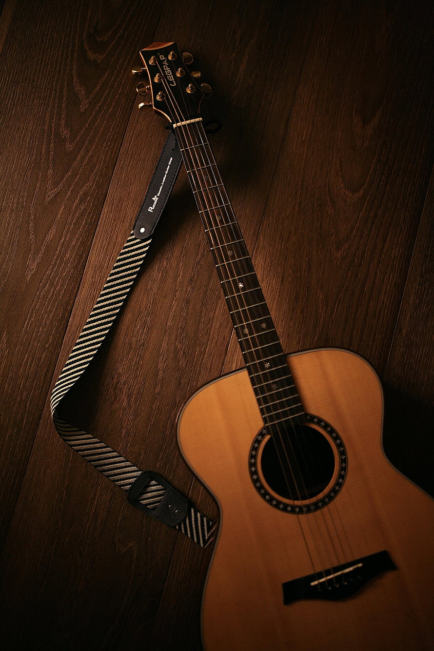 Acoustic Guitar with Striped Strap on Dark Wood Floor HD phone wallpaper