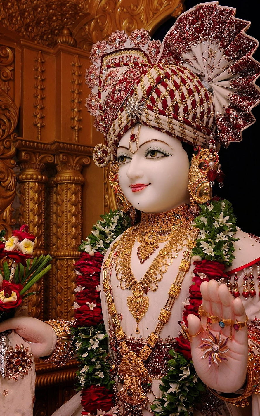 Ornate Swaminarayan Murti Adorned in Gold Jewelry and Floral Garlands HD phone wallpaper