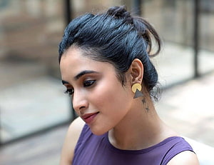 Priyanka Arul Mohan Profile Portrait with Messy Bun and Geometric Earrings HD wallpaper