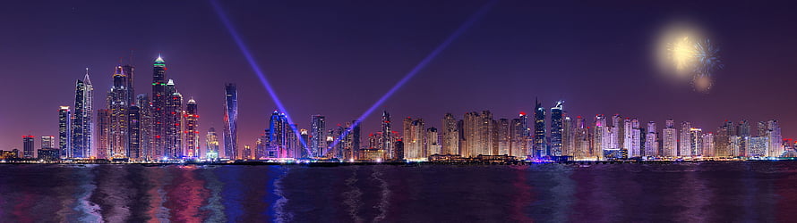 Panoramic Night Skyline of a Modern City with Fireworks and Laser Beams Over Water HD wallpaper
