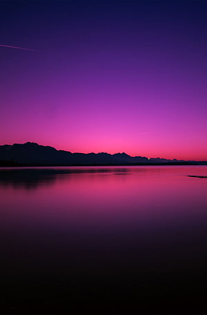 Vivid Purple and Pink Twilight Sky Over a Calm Lake with Mountain Silhouettes HD phone wallpaper
