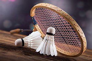 Vintage wooden badminton racket with shuttlecocks on rustic wooden surface HD wallpaper