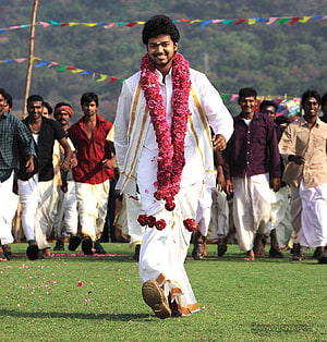 Azhagiya Tamil Magan: Young Man in White Attire with Floral Garland at Outdoor Festival HD phone wallpaper