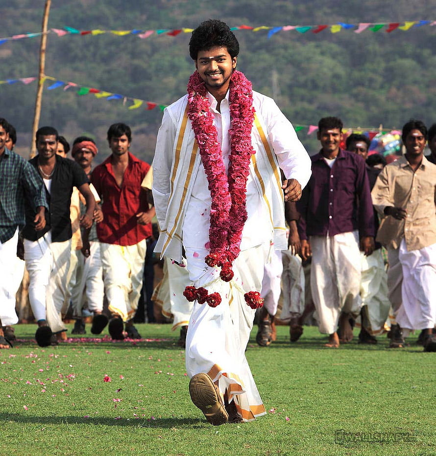 Azhagiya Tamil Magan: Young Man in White Attire with Floral Garland at Outdoor Festival HD phone wallpaper