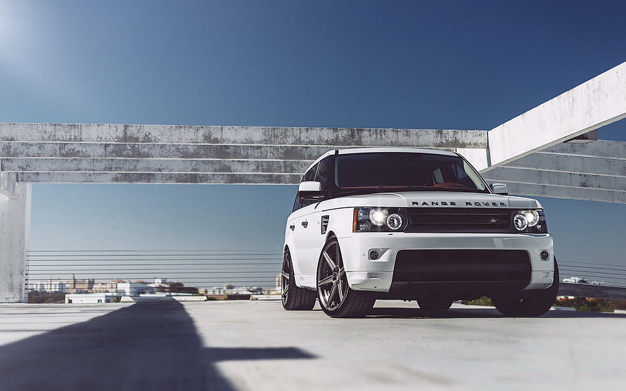 White Range Rover Sport SUV Parked on Concrete Rooftop Under Blue Sky HD wallpaper