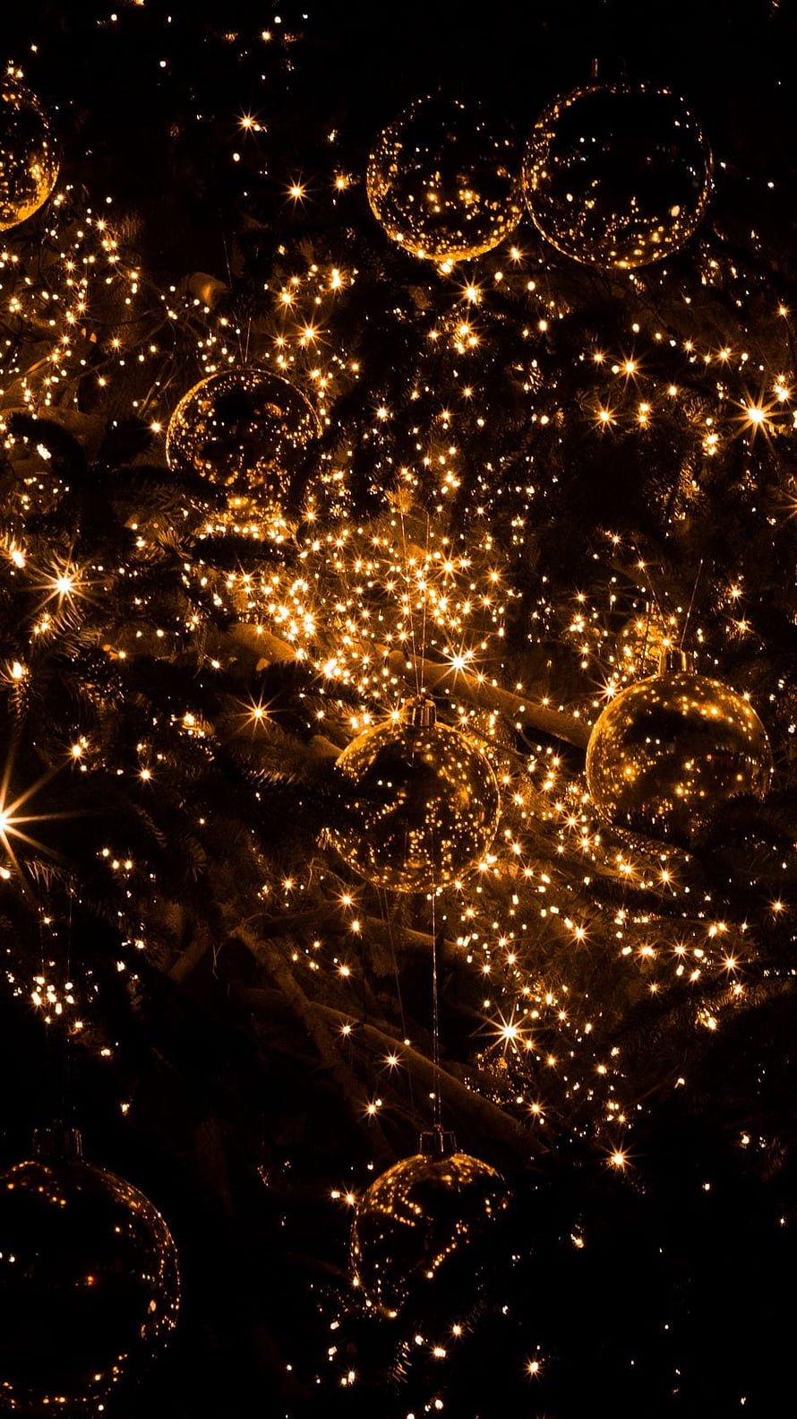 Golden Christmas Tree Ornaments and Warm Fairy Lights Against a Dark Background HD phone wallpaper