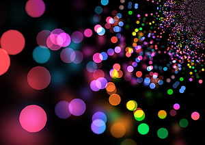 Vibrant multicolored bokeh circles on a dark background with a sparkling particle tunnel effect HD wallpaper