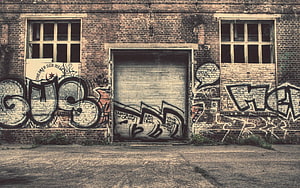 Weathered Brick Wall With Bold Urban Graffiti And Abandoned Industrial Door HD wallpaper