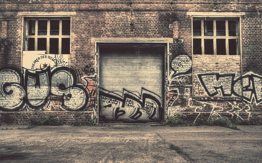 Weathered Brick Wall With Bold Urban Graffiti And Abandoned Industrial Door HD wallpaper