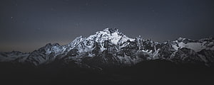 Snow-Capped Mountain Range Under a Starry Night Sky HD wallpaper